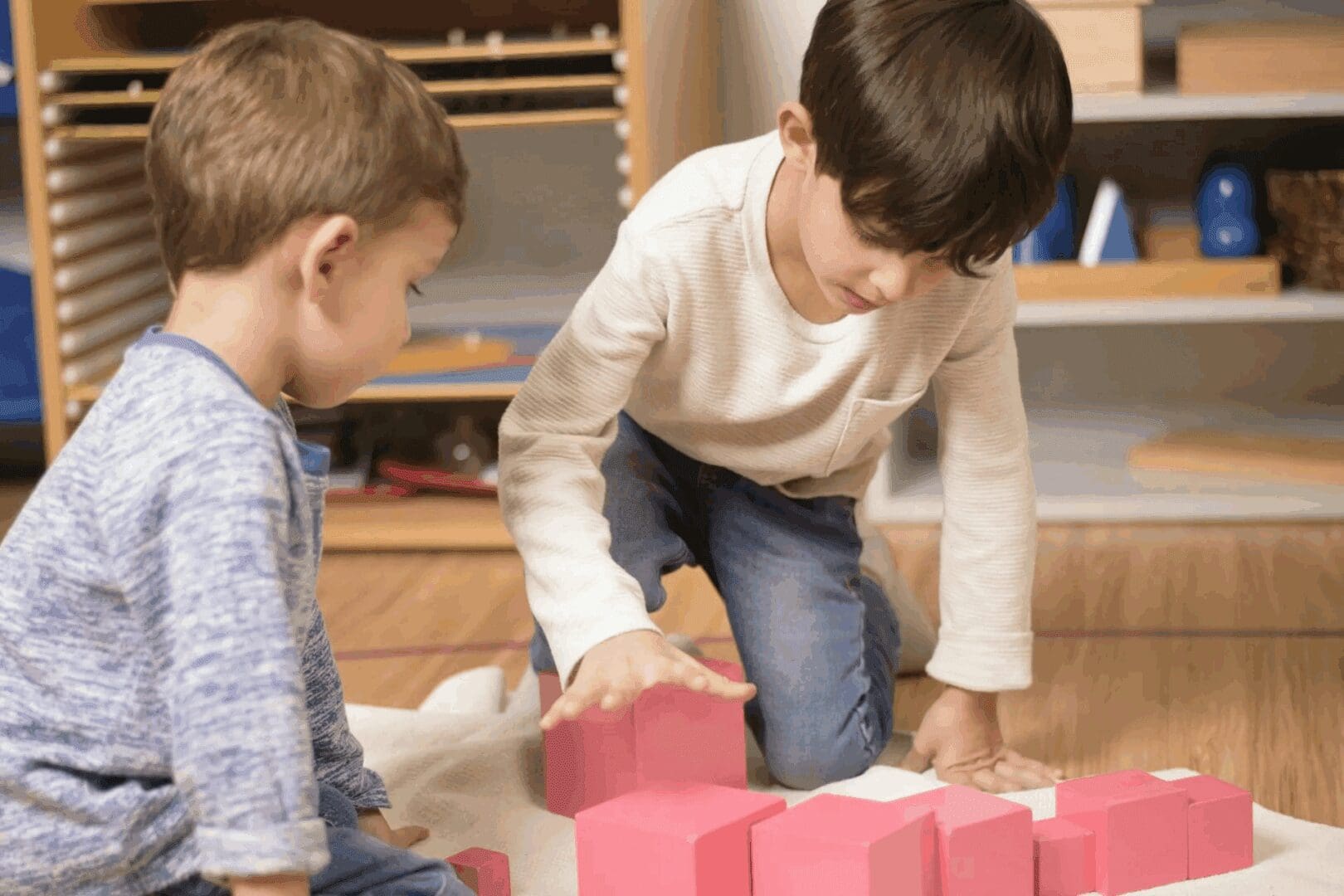 Children playing with pink building blocks.